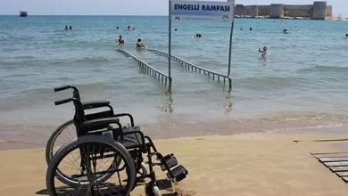 ChatGPT: Bu fotoğrafta, sahilde yer alan bir “Engelli Rampası” görülüyor. Rampa, tekerlekli sandalye kullanan bireylerin doğrudan denize girebilmesi için tasarlanmış ve denizin içine doğru uzanıyor. Ön planda boş bir tekerlekli sandalye kumsalda duruyor