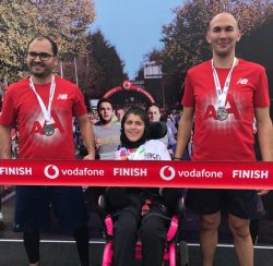 CP'li Büşra Ersoy maraton yarışları sonrası yanındaki 2 erkek gönüllülerle ile madalyaları boyunlarında yan yana duruyorlar.