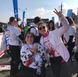 CP'li Büşra Ersoy maraton yarış alanında yanındaki kadın gönüllü ile zafer işareti yapıyor.