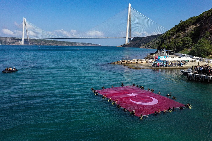 İstanbul Boğazı'ndaki 3.köprü manzarası ile denizde dev bayrak açan SAT komandosu ve engelli bireyler objektife yansıyor.