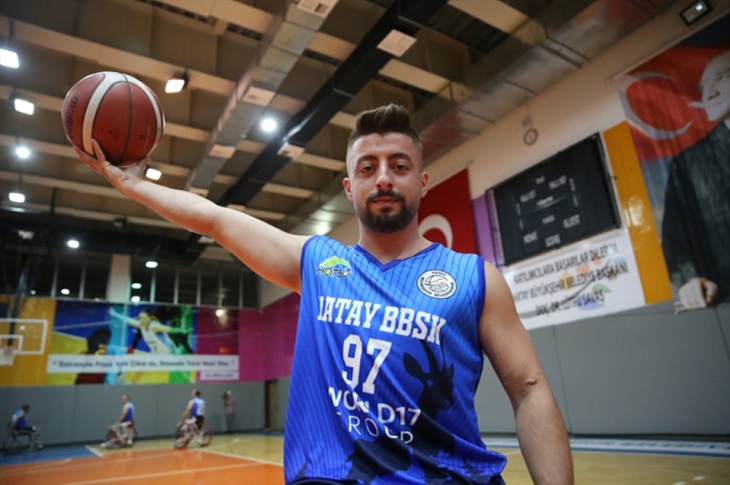 Gazi Uzman Çavuş Yusuf Deli, basketbol forması ve elindeki basketbol topuyla beraber iddialı duruşuyla objektife yansıyor.