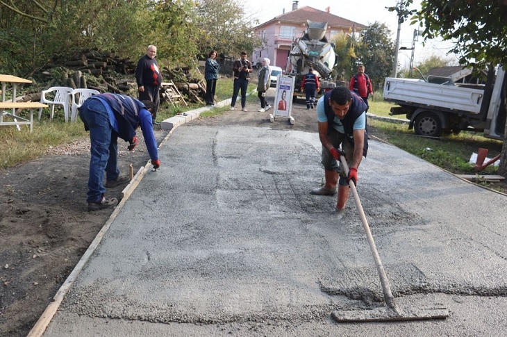 Beton yol çalışmasını gerçekleştiren belediye görevlileri objektife yansıyor.