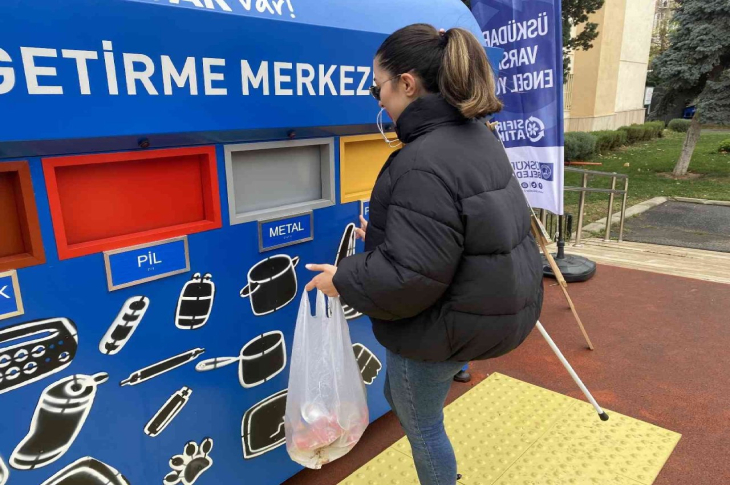 Görme engelli kadın metal atık bölümüne çöp atarken.