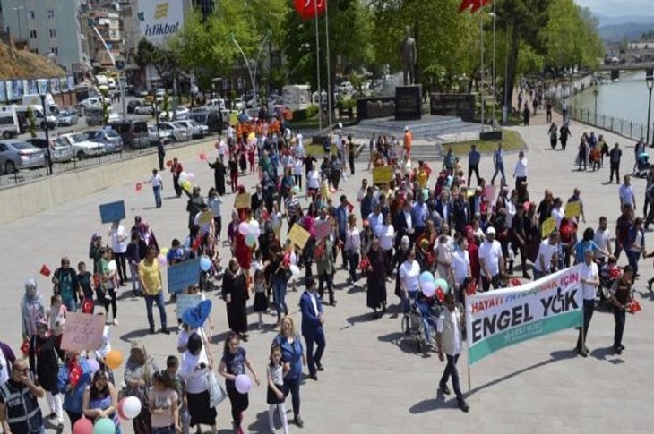 Meydanda bir araya gelen, çok sayıda vatandaş ellerindeki pankartlarla birlikte objektife yansıyor.