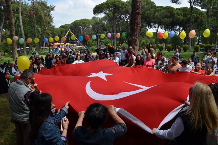 Etkinlikte buluşan çok sayıda engelli birey ve yakınlarının dev ay yıldızlı bayrağı beraber açtıkları ana dair bir görüntü objektife yansıyor.