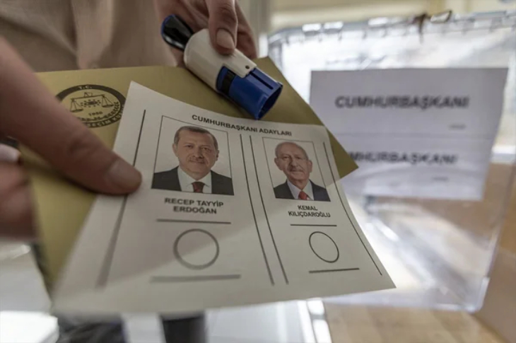 Seçim zarfı, mühür ve Cumhurbaşkanı adaylarının fotoğraflarının olduğu oy pusulası elde tutuluyor.