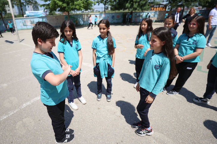 İşitme engelli erkek öğrenci Kerem Cem Elinç, okul bahçesinde arkadaşlarıyla işaret diliyle iletişim kuruyor.
