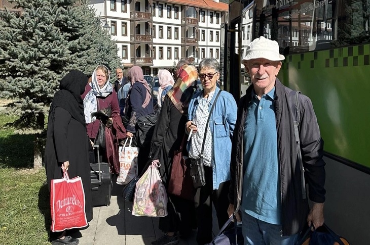 Otobüsten inen bir grup yaşlı birey objektife yansıyor.