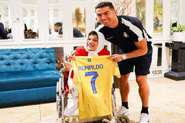 Cristiano Ronaldo, Ressam Fatemeh Hamami'ye sarı renkli 7 numaralı formasını hediye ederken poz veriyorlar.