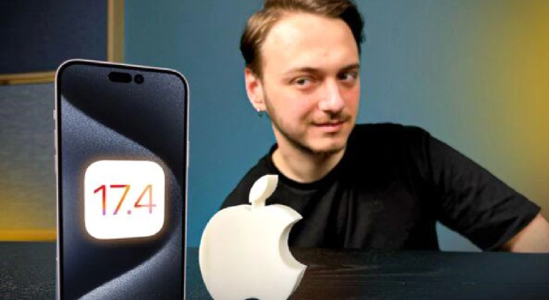 Apple 17.4 yazan bir telefon masa üstünde yanında apple markanın elma figürü ve arkada onlara bakan erkek görseli