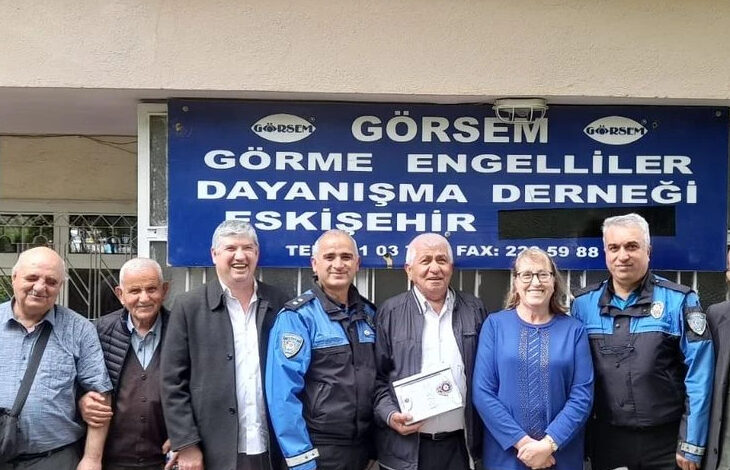 Görme Engelliler Derneği (GÖRSEM) Eskişehir Şubesi tabelası önünde polis memurları ve dernek yetkilileri var.