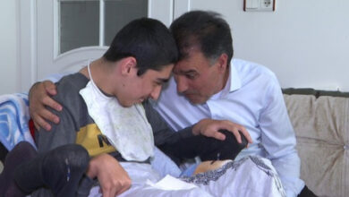 Tekerlekli sandalye kullanıcısı Umutcan Yilgin ve babası sarılıyor.