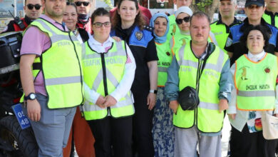 Polis memurları ve engelli bireyler bir arada ayakta duruyor.