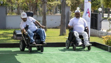 Tekerlekli sandalye kullanıcısı iki engelli birey, Bocce sporunu yapıyor.