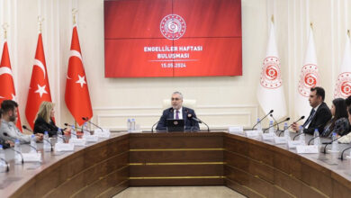 Çalışma ve Sosyal Güvenlik Bakanı Prof. Dr. Vedat Işıkhan, engelli bireyler ve İŞKUR yetkilileri bir masa etrafında oturuyor.