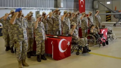 Askeri kamuflaj giyen engelli gençler, askeri yemin töreninde askeri selam veriyor.