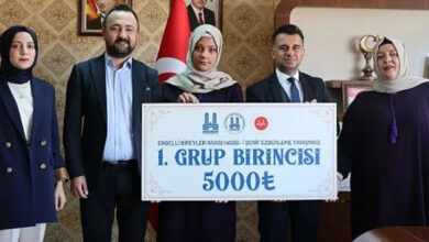 Engelli Bireyler Arası Hadis-i Şerif Ezberleme Yarışması'nı düzenleyen kişiler ve ödül çeki ile yarışmayı kazanan engelli birey fotoğraf çekiliyor.