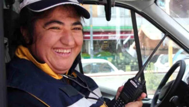 Kezban Kaya, ambulans personeli kıyafetleri giyerek, ambulans içerisinde telsizi elinde tutarak oturuyor.