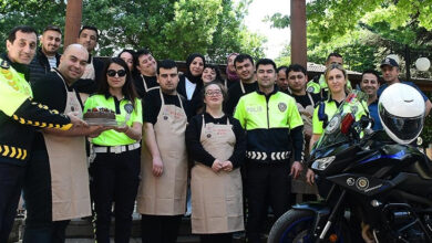 Polis memurları ellerinde engelli bireylerin yaptığı pasta ve engelli bireyler ile fotoğraf için poz veriyorlar.