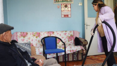 Ereğli Belediyesi personeli elektrikli süpürge ile yaşlı bir kişinin ev temizliğini yapıyor.