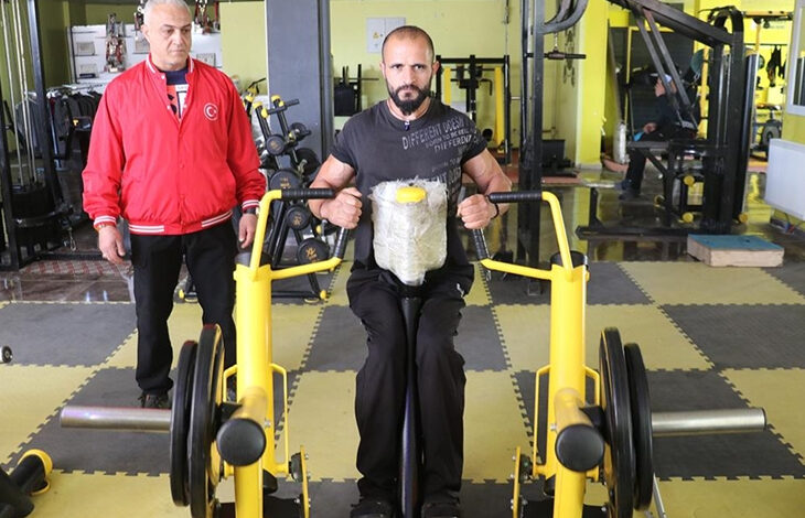 Halit Durak spor salonunda antrenörü ile birlikte antrenman yapıyor.