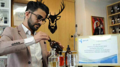 İşitme engelli genç dükkanındaki parfümleri kontrol ediyor.