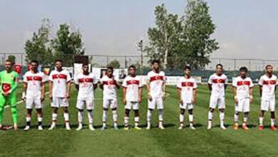 İşitme engelli sporcular futbol sahasında başlangıç seremonisi için sahanın ortasında yan yana duruyorlar.