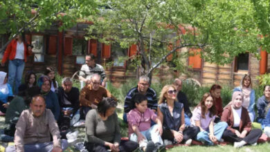 Kapadokya Engelli Yetenekler Derneği (KEYDER), engelli bireyler ve aileleri çim üzerinde oturuyor.