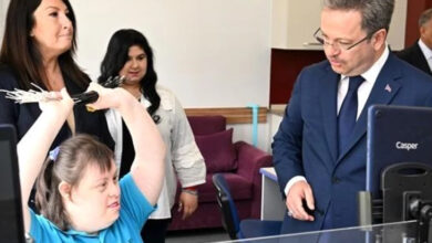 Manisa Valisi Enver Ünlü, korumalı işyeri modeliyle çalışan işyerinde, down sendromlu bireyle konuşuyor.