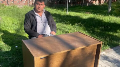 Engelli personel Nizam Batmaz, bir masanın arkasında sandalye üzerinde oturuyor.