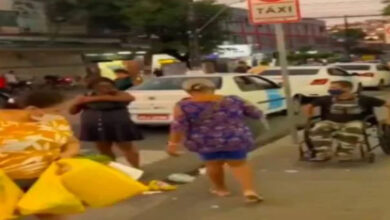 Tekerlekli sandalye kullanıcısı adam, bir caddede kaldırım üzerinde tekerlekli sandalyesini sürüyor.