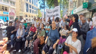 Engellilerin Haklarına Erişim Platformu'nun yapmış olduğu basın açıklamasından bir görsel, tekerlekli sandalye kullanıcısı engelli bireyler önde ve basın açıklamasını ise beyaz renkli pankartın önünde ayakta Ayşe Sarı yapıyor.