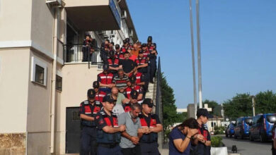 Gözaltına alınan şüpheliler tek sıra halinde ve her iki yanlarında bulunan jandarma tarafından merdivenden aşağı doğru indiriliyorlar.