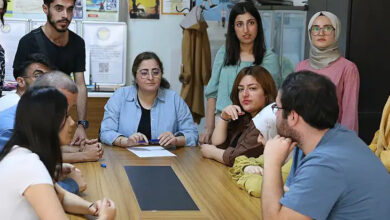 Bir masa etrafında engelli bireyler ve onları EKPSS'ye hazırlayan gönüllü üniversite öğrencileri görselde var.