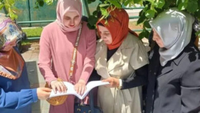 Görme engelli bireye braile alfabesi ile yazılmış bir kitap veriliyor ve çevresinde bulunan üç kişi kitabın içeriğini anlatıyorlar.