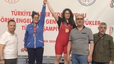 Görme engelli sporcu Melisa Durak, birincilik kürsüsünde, ikinci olan sporcuyla birlikte ellerini havaya kaldırarak seviniyorlar.