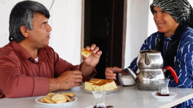 Görme engelli çift, börek yiyip, çay içerek sohbet ediyor.