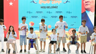 Sahnede çeşitli müzik aletleri çalarak gösteri yapan çocuklar görselde var.