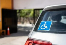 Gri renkli Hatchback tipi kasası olan otomobil arka tarafında engelli logosu var.