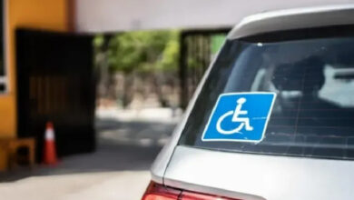 Gri renkli Hatchback tipi kasası olan otomobil arka tarafında engelli logosu var.