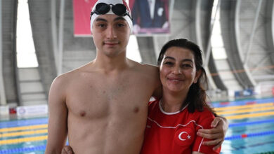 Otizmli Baha Mandalı ve annesi Benan Mandalı tek kollarıyla birbirine sarılmış, havuz önünde ayakta duruyorlar.