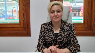 Türkiye Sakatlar Derneği Amasya Şube Başkanı Emine Hicin Arslan, dernek şubesindeki odasında koltuğunda oturuyor ve ellerini önündeki masa üzerinde birleşik şekilde tutuyor.