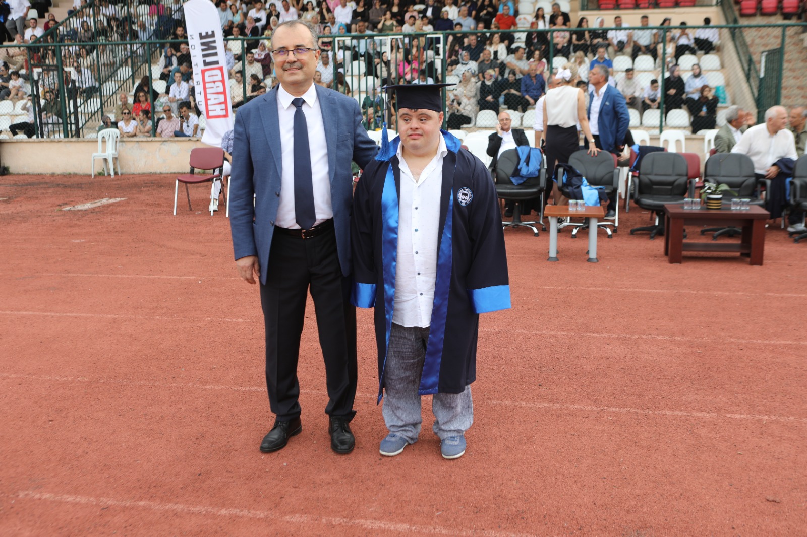 Down sendromlu Berk Canbulat ve Prof. Dr. Mustafa Kurt mezuniyet töreninde yan yana fotoğraf çekiliyor.