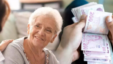 Görselin solunda, yaşlı bir kadın karşısındaki kişiye bakarak gülümsüyor ve görselin sağında kağıt para sayan el var.