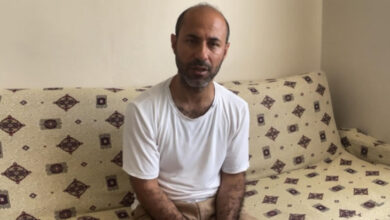 Abdülkasım Barha evde oturma odasında koltuk üzerinde oturuyor.