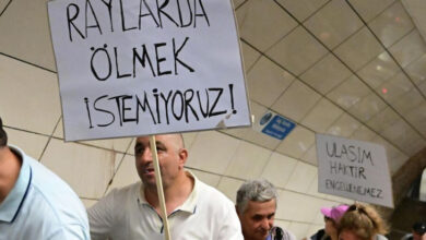 Yürüyen merdivende yukarı doğru çıkan engelli bireylerin ellerinde "Raylarda Ölmek İstemiyoruz" ile "Ulaşım Haktır Engellenemez" yazılı pankartlar var.