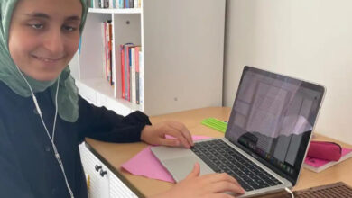 Görme engelli Berra Yami, masa başında dizüstü bilgisayar kullanıyor.