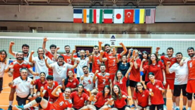 Erkekler İşitme Engelli Milli Voleybol Takımımız, toplu fotoğraf çekimi sırasında kollarını yukarı doğru açıp ellerini yumruk şeklinde tutarak sevinçlerini gösteriyorlar.