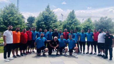 Görme Engelli B1 Futbol Millî Takımı oyuncuları ve Oğuz Çetin birlikte fotoğraf çekiliyor.