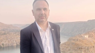 Görme engelli birey olan Isparta Memur-Sen Engelliler Komisyonu Başkanı Ecir Tülcan, göl ve kayalıklardan oluşan bir manzaraya sırtı dönük şekilde fotoğraf çektirmiş.